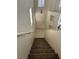 Carpeted staircase leading up into the home, showcasing tiled entry and a view of the upper level at 59 Belle Maison Ave, Las Vegas, NV 89123
