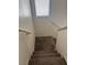 Carpeted staircase leading down into the home, highlighting neutral walls and natural lighting at 59 Belle Maison Ave, Las Vegas, NV 89123