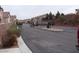 Community street view showcasing gated entry, townhomes, and landscaping at 59 Belle Maison Ave, Las Vegas, NV 89123