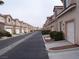 Wide community street showcasing multiple townhomes with garages and well-kept landscaping at 59 Belle Maison Ave, Las Vegas, NV 89123