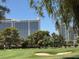 Beautiful golf course view with palm trees and modern buildings under a sunny sky at 632 Tam O Shanter, Las Vegas, NV 89109