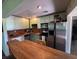 Functional kitchen with vintage cabinets, stainless steel appliances, and a large wood table at 632 Tam O Shanter, Las Vegas, NV 89109