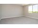 Neutral bedroom with carpet, large window, neutral paint, and baseboards at 7199 Twilight Rider Ct, Las Vegas, NV 89118