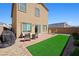 Spacious backyard featuring artificial grass, a patio, and ample space for outdoor activities at 7730 Moore Creek Ln, North Las Vegas, NV 89084