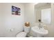 Well-lit half bathroom with a stylish pedestal sink and modern fixtures, ideal for guests at 7730 Moore Creek Ln, North Las Vegas, NV 89084