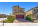 Two-story home with a well-kept yard and a two-car garage, showcasing modern architecture in a residential neighborhood at 7730 Moore Creek Ln, North Las Vegas, NV 89084