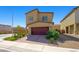 Two-story house with a two-car garage and a neatly paved driveway, embodying suburban living with its landscaped surroundings at 7730 Moore Creek Ln, North Las Vegas, NV 89084