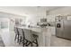 Well-lit kitchen with an island featuring granite countertops, stainless steel appliances, and an open view of the dining area at 7730 Moore Creek Ln, North Las Vegas, NV 89084
