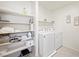 Bright laundry room with organized shelving and modern washer and dryer at 7730 Moore Creek Ln, North Las Vegas, NV 89084