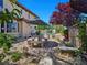 Backyard patio with an umbrella shaded dining area, water features, and mature trees at 8010 Palm Cove Ct, Las Vegas, NV 89129