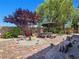 Serene backyard patio area with mature landscaping and unique decorative elements at 8010 Palm Cove Ct, Las Vegas, NV 89129