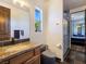Well-lit bathroom with granite counters and glass shower enclosure at 8010 Palm Cove Ct, Las Vegas, NV 89129