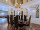 Elegant dining room with a mirrored ceiling, modern chandelier, and seating for six at 8010 Palm Cove Ct, Las Vegas, NV 89129