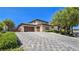 Beautiful stucco home with tile roof, stone accents, lush landscaping, and a spacious driveway leading to a three-car garage at 8010 Palm Cove Ct, Las Vegas, NV 89129