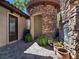 Exterior detail of a home showing stone walls, a turret-style design, and lush landscaping with potted plants at 8010 Palm Cove Ct, Las Vegas, NV 89129