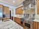 Gourmet kitchen boasts stainless steel appliances, stone accents, custom wood cabinetry, and marble countertops at 8010 Palm Cove Ct, Las Vegas, NV 89129