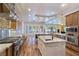Chef's kitchen featuring a large island, stainless steel appliances, custom cabinetry, and wood floors at 8010 Palm Cove Ct, Las Vegas, NV 89129
