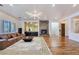 Spacious living room with a stone fireplace, modern lighting, and sleek hardwood floors at 8010 Palm Cove Ct, Las Vegas, NV 89129