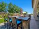 Outdoor kitchen area with built-in grill, stone countertop, and bar seating at 8010 Palm Cove Ct, Las Vegas, NV 89129