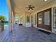 Covered patio with stone flooring that overlooks a pool with grotto and mature landscaping at 8010 Palm Cove Ct, Las Vegas, NV 89129