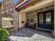 Inviting patio with a stone fireplace, comfortable seating, and an elegant entryway with wrought iron doors at 8010 Palm Cove Ct, Las Vegas, NV 89129