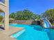 Backyard swimming pool with an impressive rock slide, creating an exciting outdoor escape at 8010 Palm Cove Ct, Las Vegas, NV 89129
