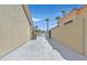 Long concrete driveway between two houses with palm trees and privacy wall in desert landscape at 814 Singing Drum Dr, Henderson, NV 89002