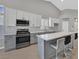 Modern kitchen featuring stainless steel appliances, white cabinetry, grey island, and modern countertops at 814 Singing Drum Dr, Henderson, NV 89002