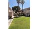 Exterior view of condos with grass yard and small trees in a residential neighborhood at 925 Falconhead Ln # 102, Las Vegas, NV 89128