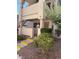 Exterior view of condo with yellow-trimmed stairs, xeriscaping and security door in a residential neighborhood at 925 Falconhead Ln # 102, Las Vegas, NV 89128