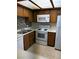 Kitchen featuring white appliances, wood cabinets, tiled backsplash, and tan flooring at 925 Falconhead Ln # 102, Las Vegas, NV 89128