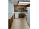 Kitchen featuring white appliances, wood cabinets, tiled backsplash, and tan flooring at 925 Falconhead Ln # 102, Las Vegas, NV 89128