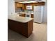Kitchen featuring white appliances, wood cabinets, tiled backsplash, and tan flooring at 925 Falconhead Ln # 102, Las Vegas, NV 89128