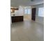 Open-concept living room and kitchen area with tile flooring and modern appliances at 925 Falconhead Ln # 102, Las Vegas, NV 89128