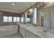 Bathroom features a tub, dual sinks, and large mirrors with great natural lighting at 975 Leadville Meadows Dr, Henderson, NV 89052