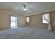 Large bedroom with a ceiling fan, large windows, and a sliding glass door at 975 Leadville Meadows Dr, Henderson, NV 89052