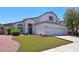 Beautiful two-story home featuring an arched entryway, a two-car garage, and a verdant lawn at 975 Leadville Meadows Dr, Henderson, NV 89052