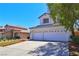 Charming two-story home with a well-manicured lawn and a spacious driveway leading to a two-car garage at 975 Leadville Meadows Dr, Henderson, NV 89052