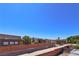 View of the neighborhood with mature trees, brick wall, and distant mountains against a blue sky at 975 Leadville Meadows Dr, Henderson, NV 89052