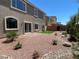 Exterior home view showing a backyard with desert landscaping, artificial turf, and a stone-lined garden at 9853 Russian Hill St, Las Vegas, NV 89141