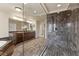 Bathroom with dual sinks, granite countertops, tiled shower, and wood-look floors at 9853 Russian Hill St, Las Vegas, NV 89141