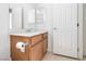 Well-lit half bath featuring a wood vanity with marble countertop and decorative mirror at 10013 Sable Point St, Las Vegas, NV 89178