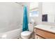 Well-lit bathroom featuring a bathtub, white tiling, vanity, and blue shower curtain at 10013 Sable Point St, Las Vegas, NV 89178