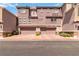 Townhome's exterior showcases a warm, mauve hue with complementary stone accents, highlighting a welcoming garage entry at 10013 Sable Point St, Las Vegas, NV 89178
