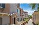 Charming exterior of a row of townhomes featuring decorative accents, covered entries, and well-maintained landscaping at 10013 Sable Point St, Las Vegas, NV 89178