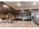 Modern kitchen showcases dark wood cabinets, granite countertops, stainless appliances, and stylish backsplash at 12237 Plum Mist Ct # 4, Las Vegas, NV 89183