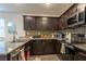 The well-equipped kitchen features granite counters, stainless steel appliances and dark wood cabinets at 12237 Plum Mist Ct # 4, Las Vegas, NV 89183