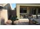 Backyard with a covered patio and outdoor seating, cactus, and desert landscaping at 1504 Andrew David Ave, North Las Vegas, NV 89086