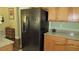 Modern kitchen showcasing a stainless steel refrigerator alongside wood cabinets and granite countertops at 1504 Andrew David Ave, North Las Vegas, NV 89086