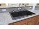 Modern dark sink and granite countertops with wooden cabinets in a kitchen at 1504 Andrew David Ave, North Las Vegas, NV 89086
